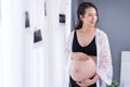 Pregnant woman looking her belly with window background Royalty Free Stock Photo