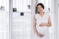 Pregnant woman looking her belly with window background Royalty Free Stock Photo