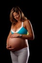 Pregnant woman looking and holding her belly Royalty Free Stock Photo