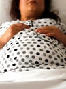 Pregnant woman lying on bed