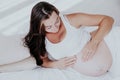 A pregnant woman is lying in bed waiting for the birth of a child Royalty Free Stock Photo