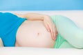 Pregnant woman lying on couch touching her belly Royalty Free Stock Photo