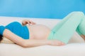 Pregnant woman lying on couch touching her belly Royalty Free Stock Photo