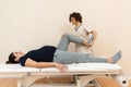 A pregnant woman lying on a massage table while a physiotherapist massages her legs at a health center Royalty Free Stock Photo