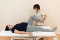 A pregnant woman lying on a massage table while a physiotherapist massages her legs at a health center Royalty Free Stock Photo