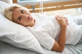 Pregnant woman lying on medical bed, embracing her belly and looking at camera Royalty Free Stock Photo