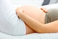 Pregnant woman lying on sofa and holding belly Royalty Free Stock Photo