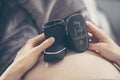 Pregnant woman lying on the sofa and holding shoes unborn child. Royalty Free Stock Photo