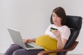 Pregnant woman makes a purchase on the Internet Royalty Free Stock Photo