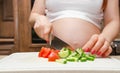 Pregnant woman makes salad