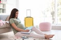 Pregnant woman making list while packing suitcase for maternity hospital Royalty Free Stock Photo