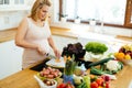 Pregnant woman making a meal in kitchen Royalty Free Stock Photo