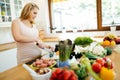 Pregnant woman making a meal in kitchen Royalty Free Stock Photo