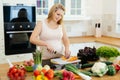 Pregnant woman making a meal in kitchen Royalty Free Stock Photo