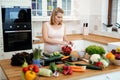 Pregnant woman making a meal in kitchen Royalty Free Stock Photo