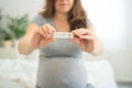 Pregnant woman making test. Close up of fingers holding express antigen covid test, negative result