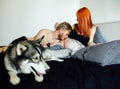 Pregnant woman, man and dog lying on a bed Royalty Free Stock Photo