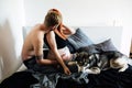 Pregnant woman, man and dog sitting on a bed Royalty Free Stock Photo