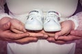 Pregnant woman and man holding baby shoes Royalty Free Stock Photo