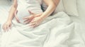 Pregnant woman with man hug belly in bed. Selective focus Royalty Free Stock Photo