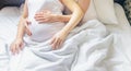 Pregnant woman with man hug belly in bed. Selective focus Royalty Free Stock Photo