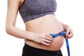 Pregnant woman measures her belly with a measure Royalty Free Stock Photo