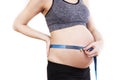 Pregnant woman measures her belly with a measure Royalty Free Stock Photo