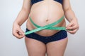 A pregnant woman measures her belly with a measuring tape Royalty Free Stock Photo