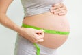 Pregnant woman measures her stomach. Pregnancy and weight gain. Pregnancy and sport. Big belly. Trimester Royalty Free Stock Photo