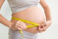 Pregnant woman measures her stomach. Pregnancy and weight gain. Pregnancy and sport. Big belly. Trimester Royalty Free Stock Photo