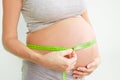 Pregnant woman measures her stomach. Pregnancy and weight gain. Pregnancy and sport. Big belly. Trimester Royalty Free Stock Photo