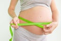 Pregnant woman measures her stomach. Pregnancy and weight gain. Pregnancy and sport. Big belly. Trimester Royalty Free Stock Photo