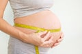 Pregnant woman measures her stomach. Pregnancy and weight gain. Pregnancy and sport. Big belly. Trimester Royalty Free Stock Photo