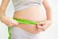 Pregnant woman measures her stomach. Pregnancy and weight gain. Pregnancy and sport. Big belly. Trimester Royalty Free Stock Photo