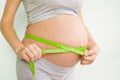 Pregnant woman measures her stomach. Pregnancy and weight gain. Pregnancy and sport. Big belly. Trimester Royalty Free Stock Photo