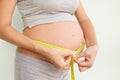 Pregnant woman measures her stomach. Pregnancy and weight gain. Pregnancy and sport. Big belly. Trimester Royalty Free Stock Photo