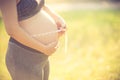 Pregnant woman measuring her belly with tape measure Royalty Free Stock Photo