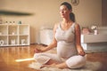 Pregnant woman meditates indoor in yoga pose. Woman enjoying in