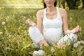 Pregnant woman meditates outdoor in yoga pose. Royalty Free Stock Photo