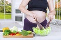 Pregnant woman mixing salad on the bowl Royalty Free Stock Photo