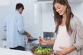 Pregnant woman mixing a salad in the kitchen