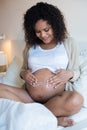 Pregnant woman moisturizing belly