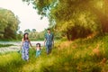 Pregnant woman mother to be in wreath and blue dress with her daughter and husband walking together near scenic river in sunset Royalty Free Stock Photo