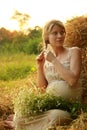 Pregnant woman on nature near the haystacks