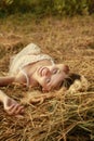 Pregnant woman on nature near the haystacks