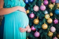 Pregnant woman near Christmas tree