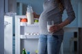 The pregnant woman near fridge looking for food and snacks at night Royalty Free Stock Photo