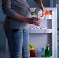 Pregnant woman near fridge looking for food and snacks at night Royalty Free Stock Photo