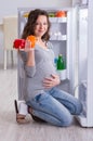 Pregnant woman near fridge looking for food and snacks Royalty Free Stock Photo