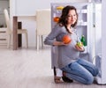 Pregnant woman near fridge looking for food and snacks Royalty Free Stock Photo